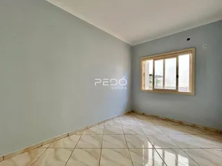 Vista interna de uma sala com paredes claras e piso de cerâmica.