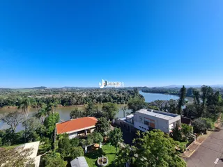 Vista aérea de uma propriedade com paisagem de rio e vegetação.