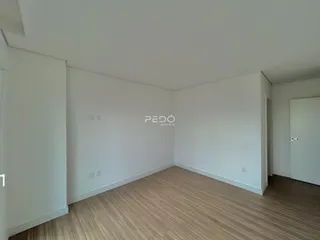 Ambiente interno de uma sala com piso de madeira clara.