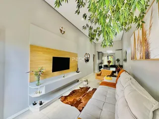 Sala de estar moderna com parede de madeira e sofá claro.