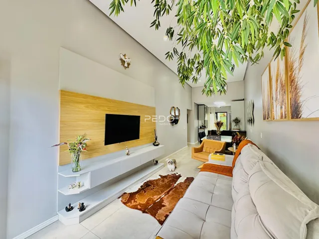 Sala de estar moderna com parede de madeira e sofá claro.