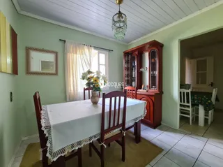 Mesa de jantar com toalha branca em um ambiente interno.
