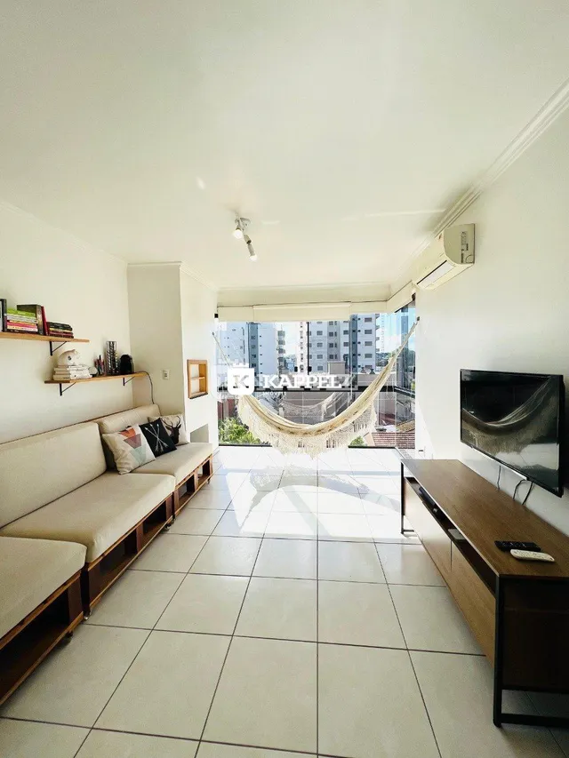 Sala de estar com sofá e piso de cerâmica.