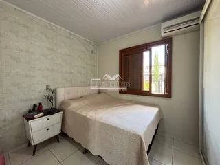 Quarto com cama e móveis brancos em um imóvel no Brasil.