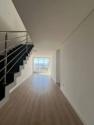Corredor com escadaria e vista da cidade através de uma janela.
