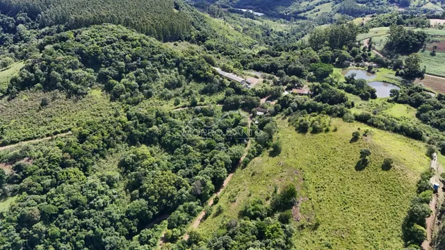 Vista aérea de uma paisagem verde com colinas e áreas de vegetação na região de Lajeado.