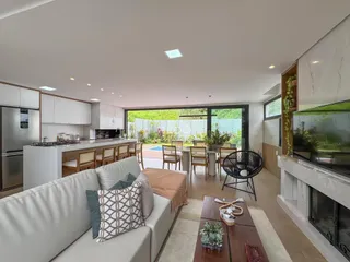 Sala de estar com cozinha integrada e acesso ao jardim.