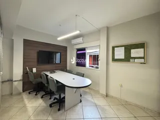 Ambiente interno com mesa de reunião e parede de madeira.
