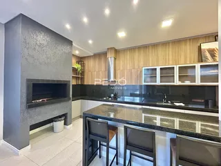 Ambiente moderno com lareira e cozinha integrada em um imóvel.