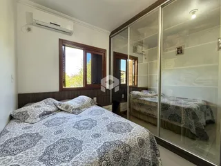 Quarto com cama e janela de madeira.