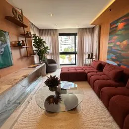Foto interna de uma sala de estar com sofá e decoração.