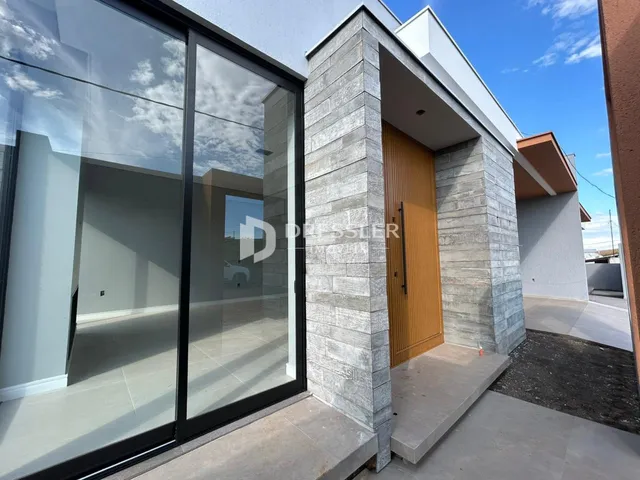 Fachada moderna de uma residência com grandes portas de vidro e revestimento de pedra.