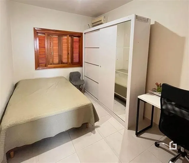Quarto com cama e guarda-roupa em ambiente interno.