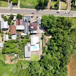 Vista aérea de uma propriedade residencial com área verde densa em Lajeado.