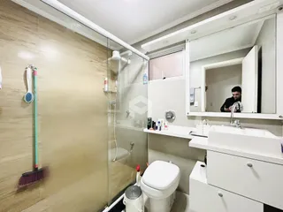 Banheiro com box de vidro e louças brancas em imóvel no Brasil.