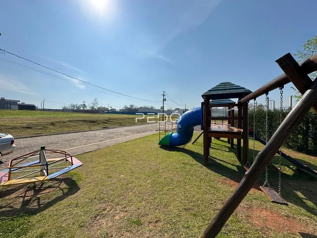 Área externa com gramado e estrutura de playground de madeira.
