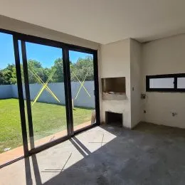Ambiente interno com grandes portas de vidro que dão vista para um gramado.