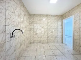 Interior de um banheiro com revestimento de azulejos claros.