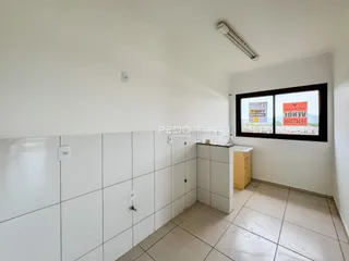 Vista interna de um corredor com revestimento de cerâmica branca.