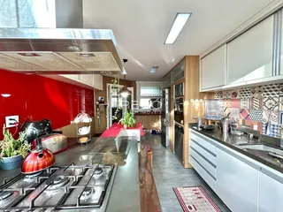 Cozinha moderna com armários brancos e detalhes vermelhos em Lajeado.