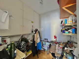 Interior de um cômodo com armários brancos e piso de madeira.