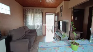 Sala de estar com teto de madeira e cortinas na sala de Lajeado.
