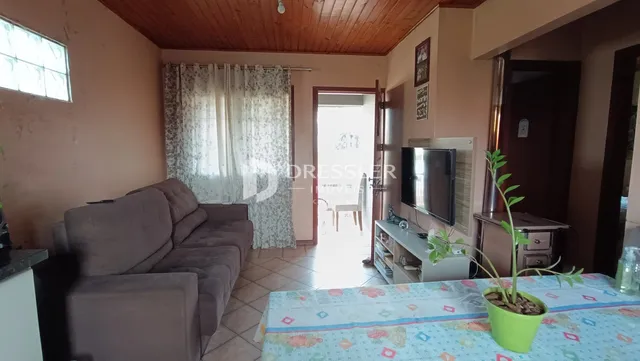 Sala de estar com teto de madeira e cortinas na sala de Lajeado.