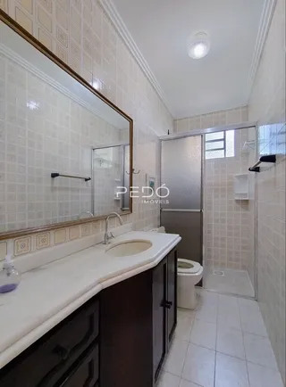 Foto de um banheiro com azulejos brancos e bancada de pia.