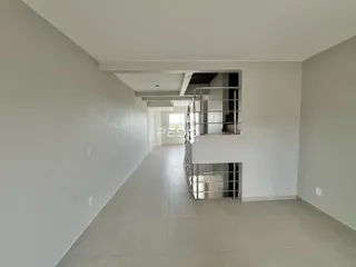 Corredor interno de um apartamento moderno com piso claro e escada de metal.