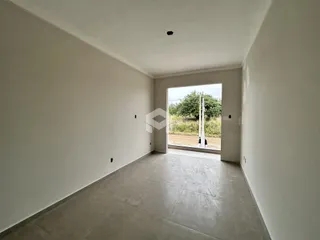 Foto de um ambiente interno com paredes brancas e piso de concreto.