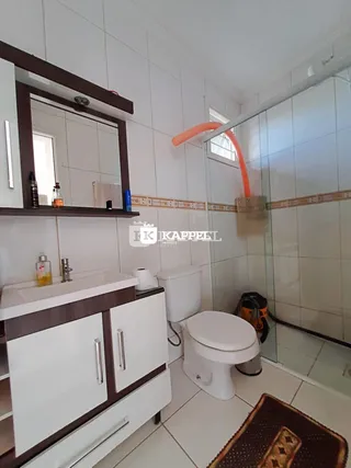 Foto de um banheiro com revestimento de azulejos brancos e bancada.