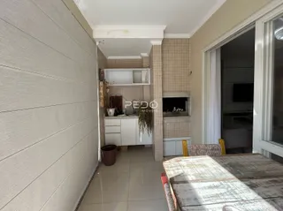 Vista de um corredor interno com revestimento de azulejos e acesso a uma área de cozinha.