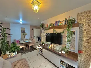 Ambiente interno de sala de estar com mesa de jantar e decoração de madeira.