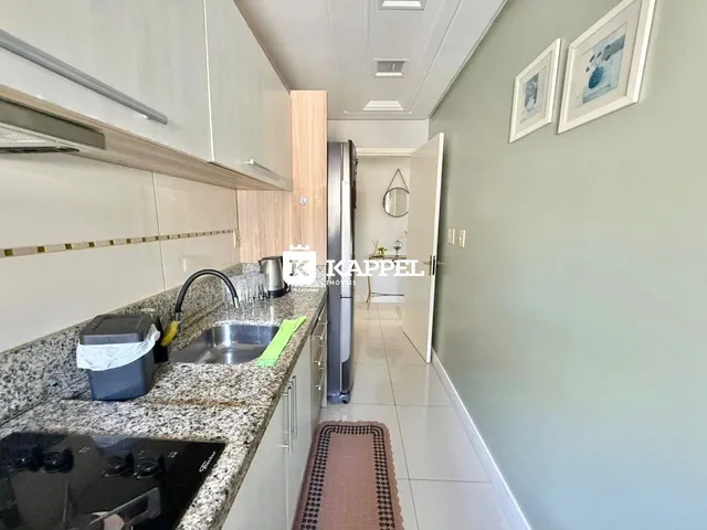 Cozinha moderna com bancada de granito e armários brancos.