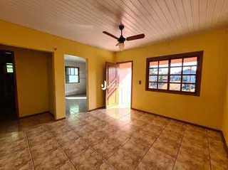 Interior de uma sala com piso de cerâmica e paredes amarelas.