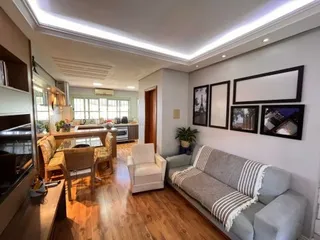 Uma sala de estar com piso de madeira e iluminação embutida.