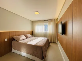 Quarto com cama e armário de madeira em um apartamento.