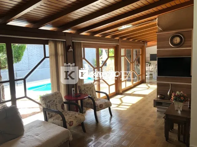 Sala de estar com piso de madeira e acesso a uma área externa.