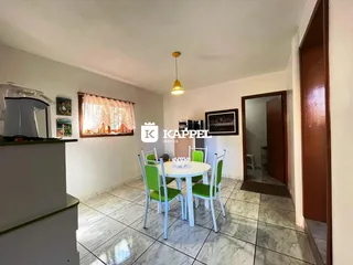 Foto de uma sala de jantar com mesa e cadeiras brancas em um imóvel.