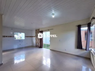 Sala ampla com piso claro e grandes janelas.