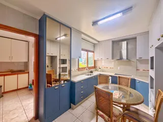 Uma cozinha com armários azuis e mesa de jantar em um imóvel no Brasil.