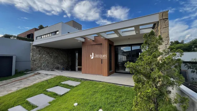 Fachada moderna de uma casa com revestimento de pedra e detalhes em madeira.