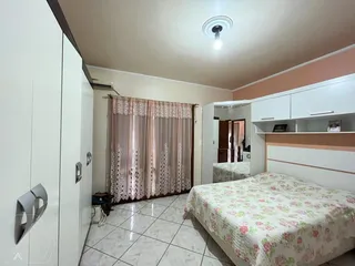 Foto de um quarto com armário branco e cortinas na janela.