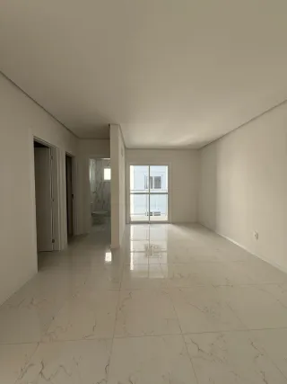 Hall de entrada com piso de mármore claro e paredes brancas.