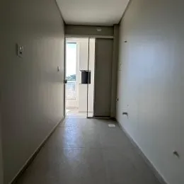 Corredor interno com paredes brancas e piso claro.