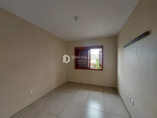 Hall de corredor com piso de cerâmica claro.