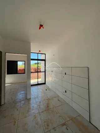 Vista interna de um corredor com piso de cerâmica claro e paredes brancas.