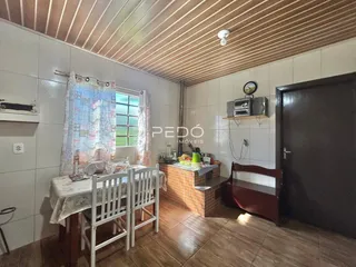 Ambiente interno com mesa de jantar e piso de madeira em imóvel no Brasil.