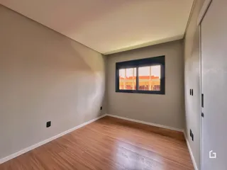 Foto de um ambiente interno com piso de madeira clara e parede lisa.