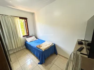 Quarto com cama azul e cortinas brancas em um ambiente interno.